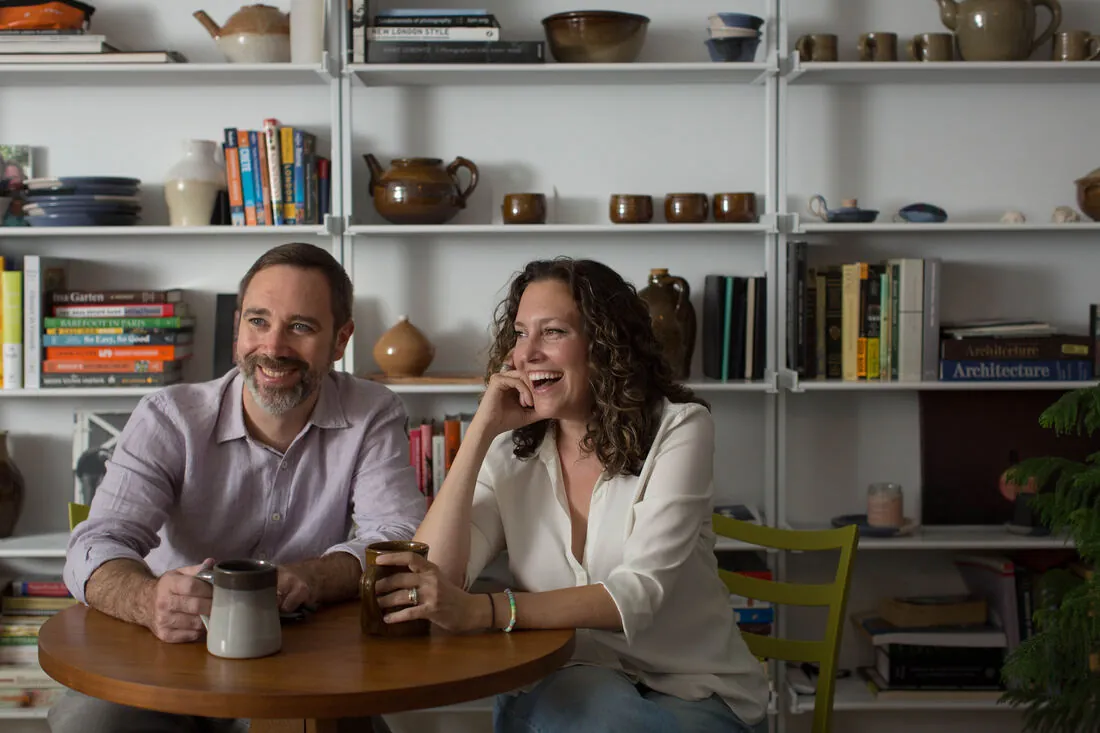Erica LiBritz and Patrick Koch, ANDIAMO founding partners, at a table in a bookshelf-lined room
