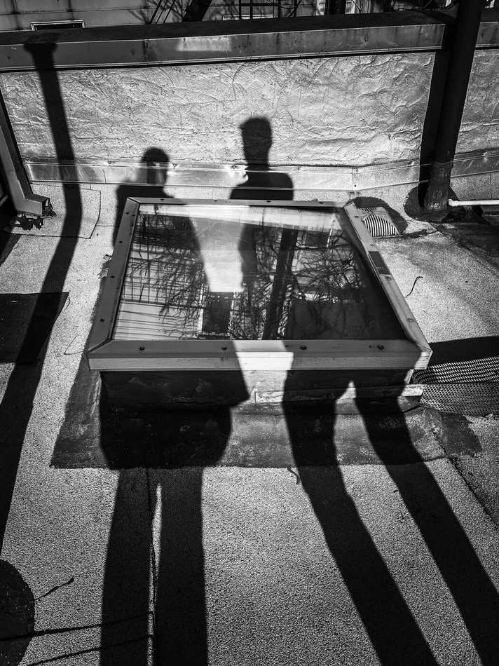 Shadows cast over a skylight opening on a rooftop