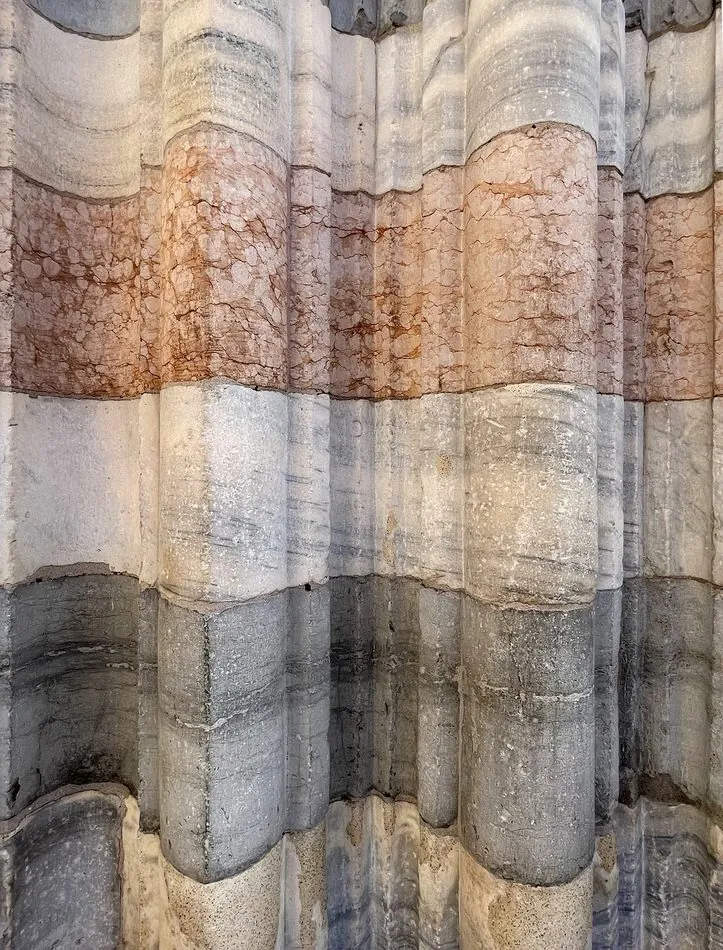 Banded stone column in layered pink and grey marble